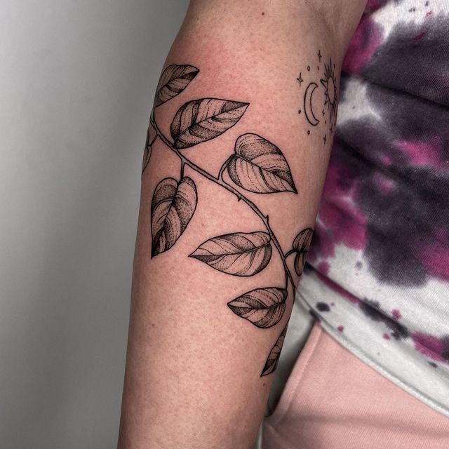 a woman's arm with leaves on it