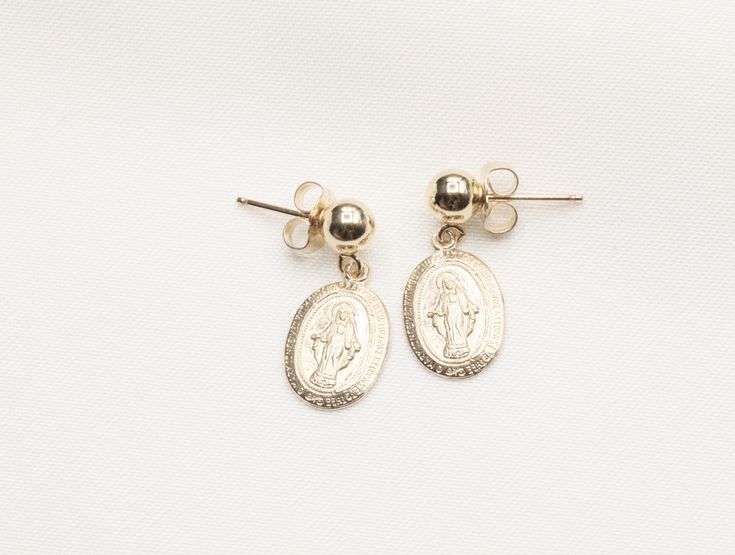 14k Gold Filled Virgin Mary Earrings / Miraculous Earrings / Catholic Jewelry / Gold Coin Jewelry / Catholic Gifts - 9 x 13mm Gold Filled Virgin Mary Pendant - Front design: Mama Mary - Back design: letter M with a cross on top and scattered stars - 14k Gold Filled 5mm stud - Sold as a pair - Tarnish free, hypoallergenic, nickel free and safe for sensitive skin 💰 We guaranteed fair pricing on all our jewelry. 🍃 All our jewelry comes with a modern style packaging, which includes a classy suede Dainty 14k Gold Earrings With Charms, Gold Drop Earrings With Charms, 14k Gold Filled Charms Drop Earrings, 14k Gold Filled Drop Earrings With Charms, 14k Gold Tarnish Resistant Plug Earrings As Gift, 14k Gold Tarnish-resistant Plug Earrings As Gift, Tarnish Resistant 14k Gold Plug Earrings As Gift, Yellow Gold Charm Earrings For Gift, Yellow Gold 14k Charm Earrings