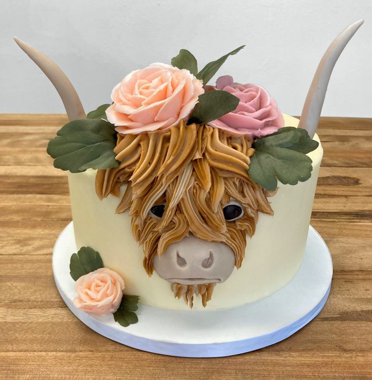 a cake decorated to look like a cow with horns and flowers on it's head