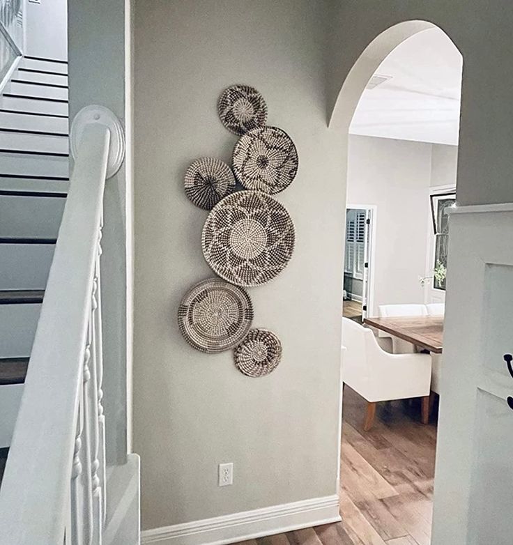 there are baskets hanging on the wall next to the stair case in this house,