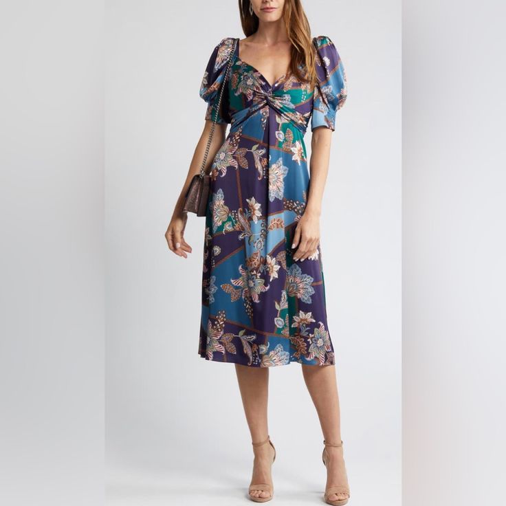 Elbow-Length Puff Sleeves And A Twist At The Bust Bring The Chic Drama To A Midi-Length Satin Dress Covered In A Floral-Paisley Print. 49" Length (Size 8) V-Neck Elbow-Length Sleeves Lined 100% Polyester Hand Wash, Dry Flat Imported Floral Print Knee-length Midi Dress For Night Out, Blue Mid-length Ruched Dress, Purple Ruched Midi Dress, Chic Purple Puff Sleeve Midi Dress, Purple Puff Sleeve Evening Dress, Chic Purple Midi Dress With Puff Sleeves, Feminine Purple Midi Dress, Chic Purple Short Sleeve Midi Dress, Purple Short Sleeve Midi Dress For Evening