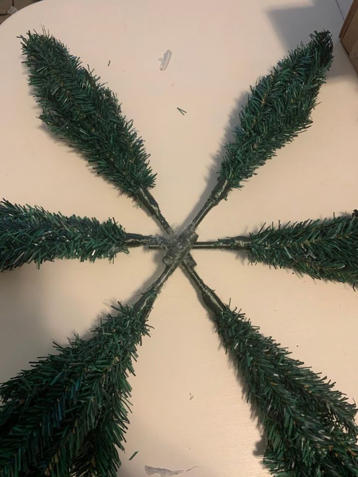 a white table topped with green plants on top of it's sides and an upside down view of the leaves