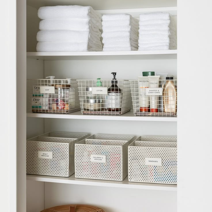 the shelves are organized with baskets and towels