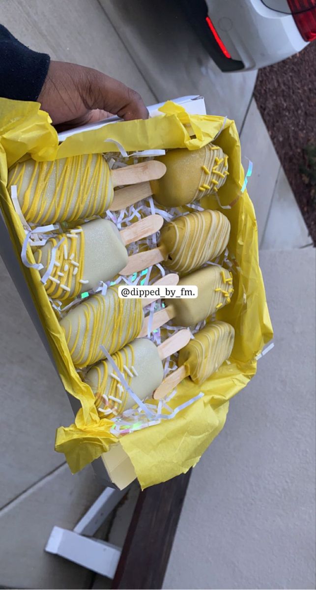 a person holding a yellow bag full of cookies and marshmallows in it