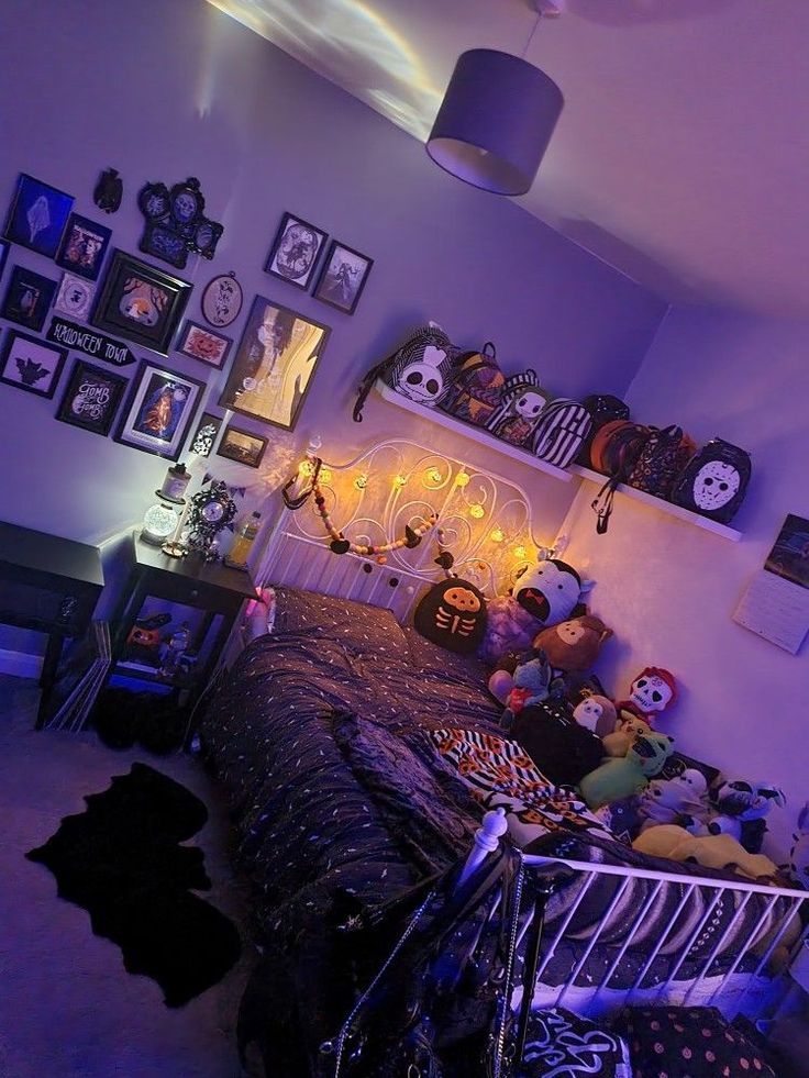 a bedroom decorated for halloween with decorations and pictures on the wall above the bed, along with stuffed animals