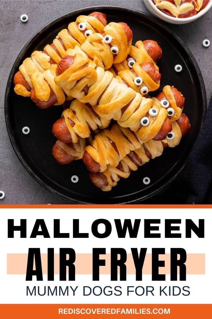 halloween air fryer dogs on a black plate with googly eyes in the middle