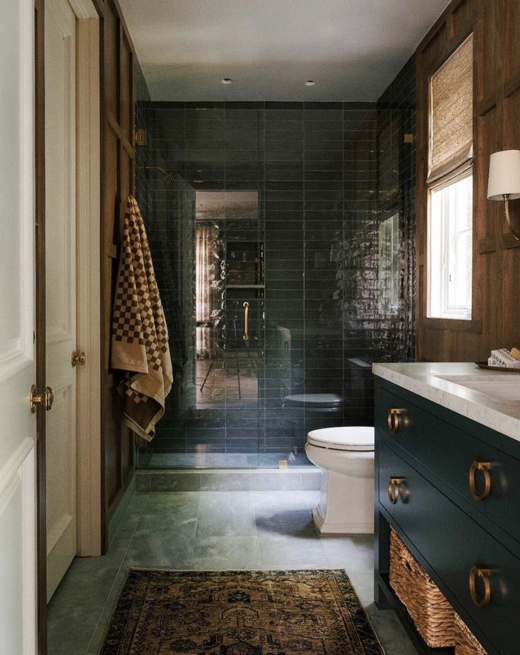 a bathroom with a rug, sink and toilet next to a doorway that leads to another room