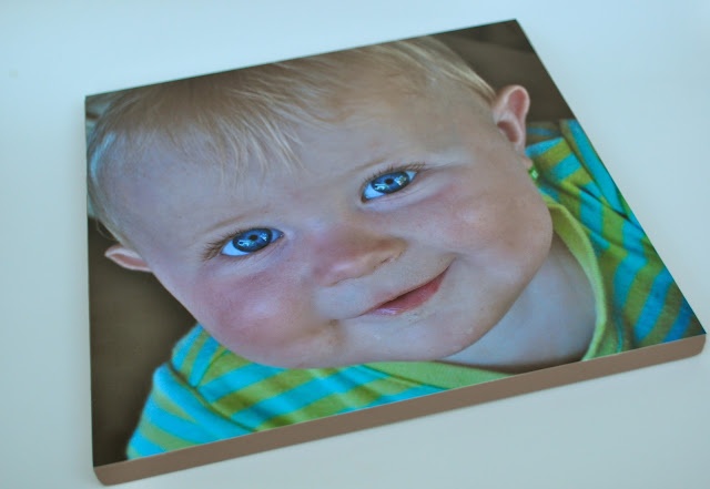 a baby with blue eyes is smiling for the camera