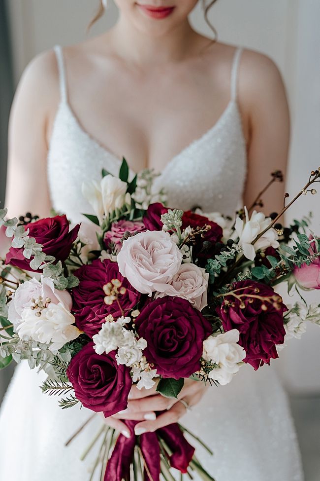 a woman holding a bouquet of flowers in her hands