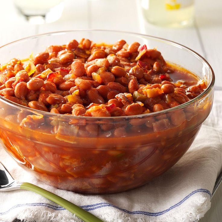 a glass bowl filled with beans on top of a table