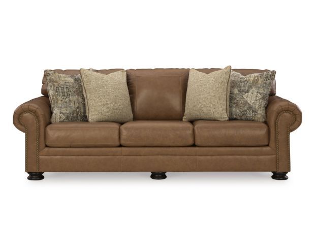 a brown leather couch with pillows on the armrests and two throw pillows in front of it