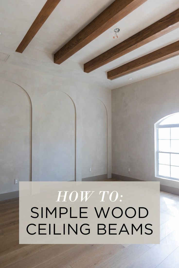 an empty room with white walls and wood beams on the ceiling is featured in this article