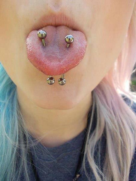 a woman with blonde hair and piercings on her tongue