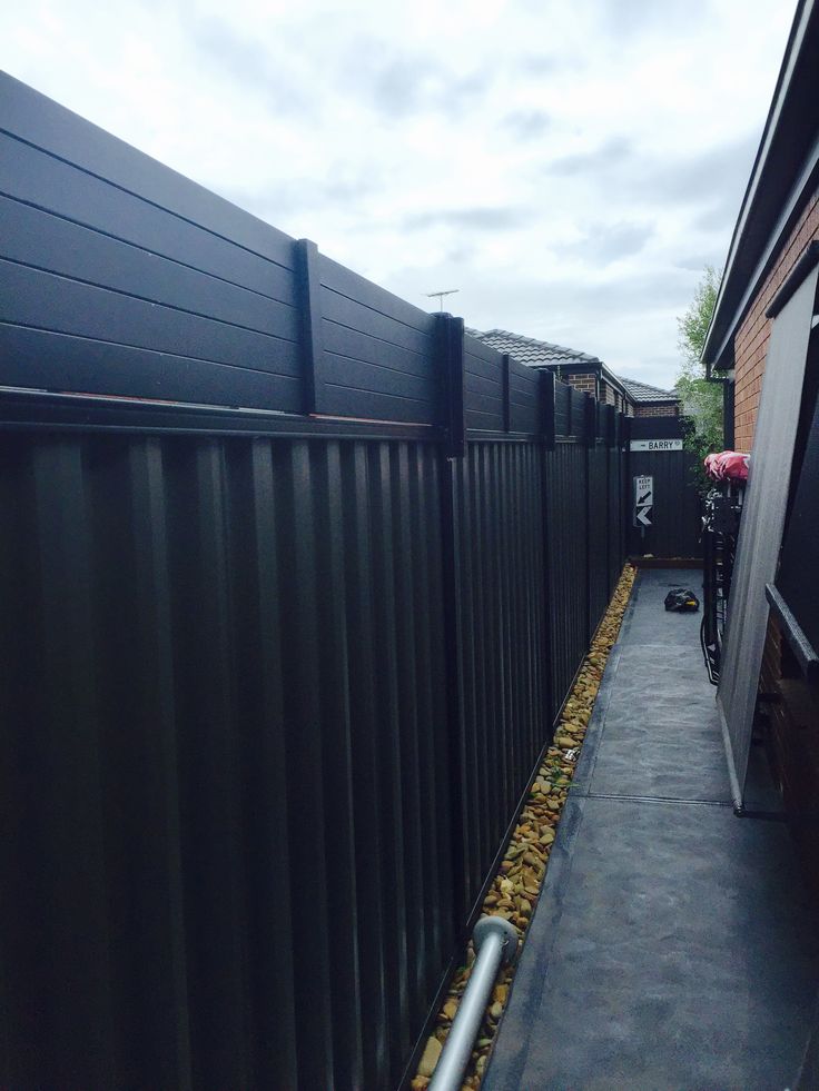 a long black fence next to a brick building