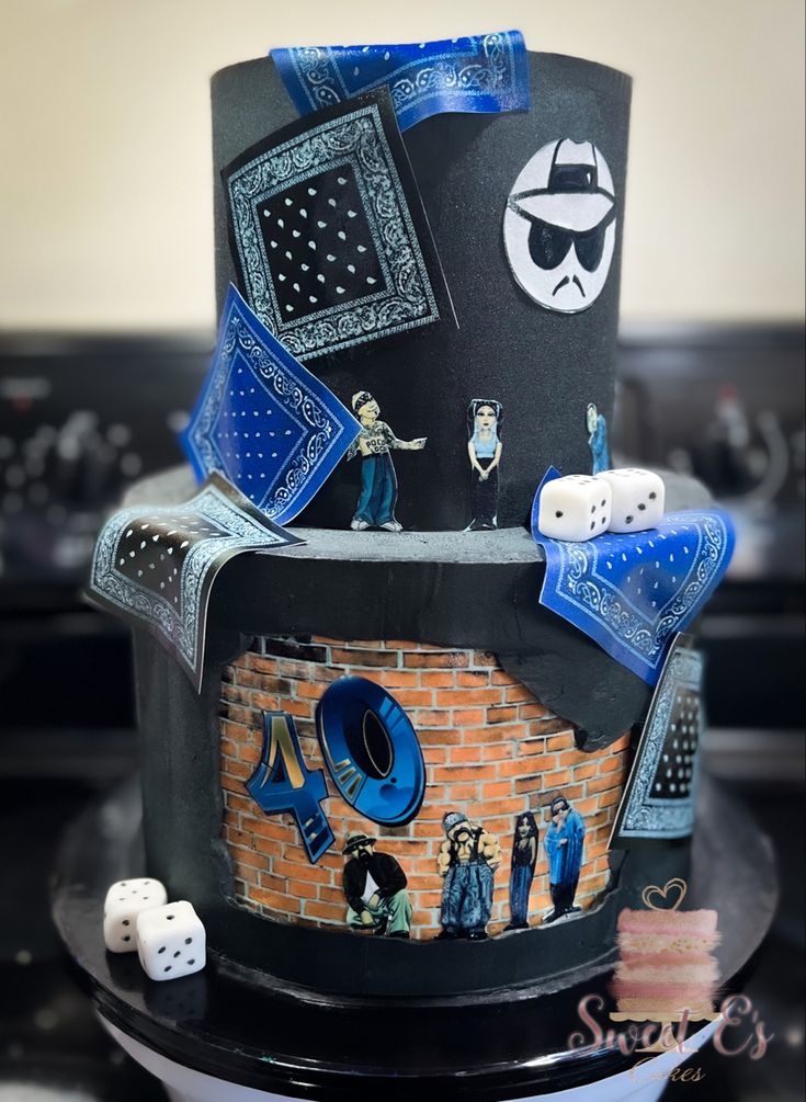 a black cake with blue decorations and dice