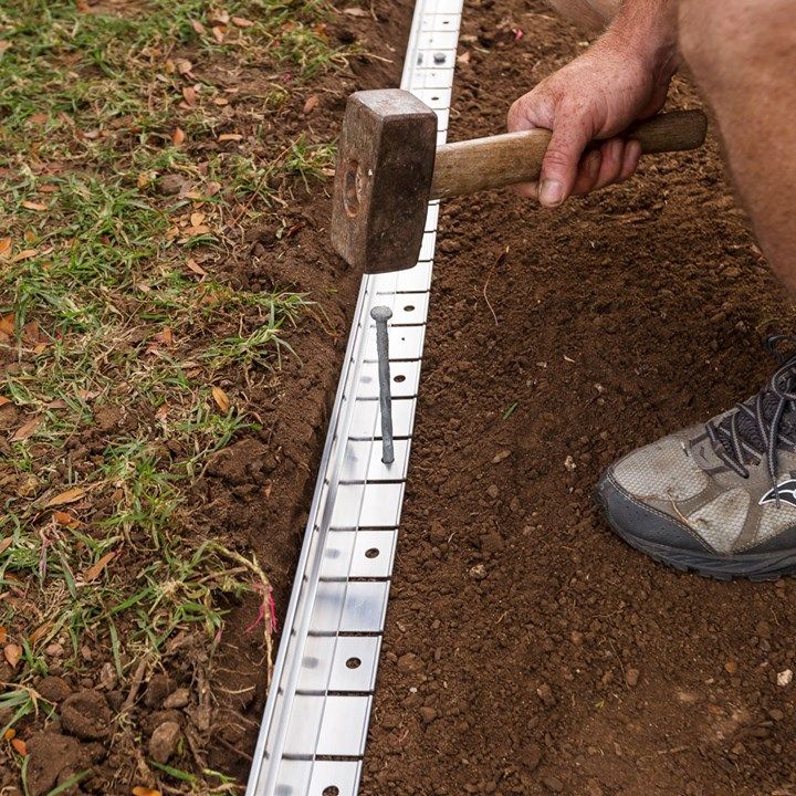 a man is digging in the ground with a hammer