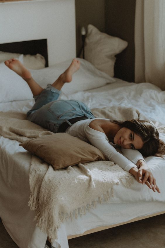 a woman laying on top of a bed in a bedroom