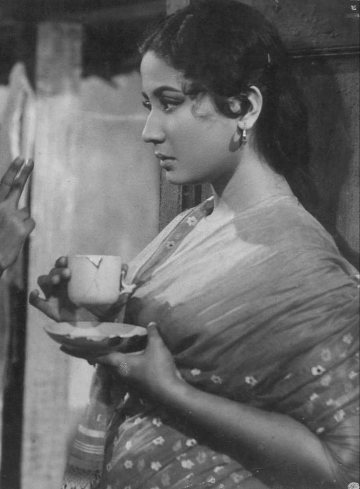 an old black and white photo of a woman holding a tea cup in her hand