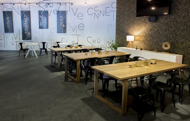 an empty restaurant with tables and chairs in front of a large screen tv mounted on the wall