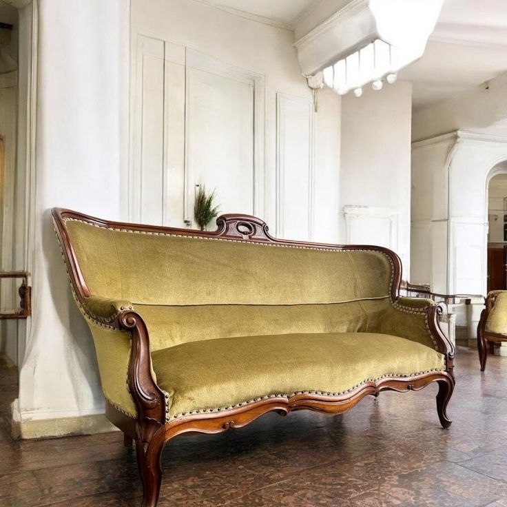 an old fashioned couch sitting on top of a hard wood floor