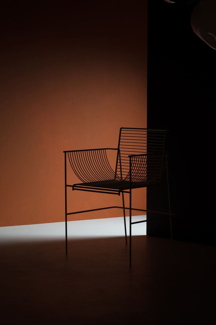 a chair sitting in front of an orange wall