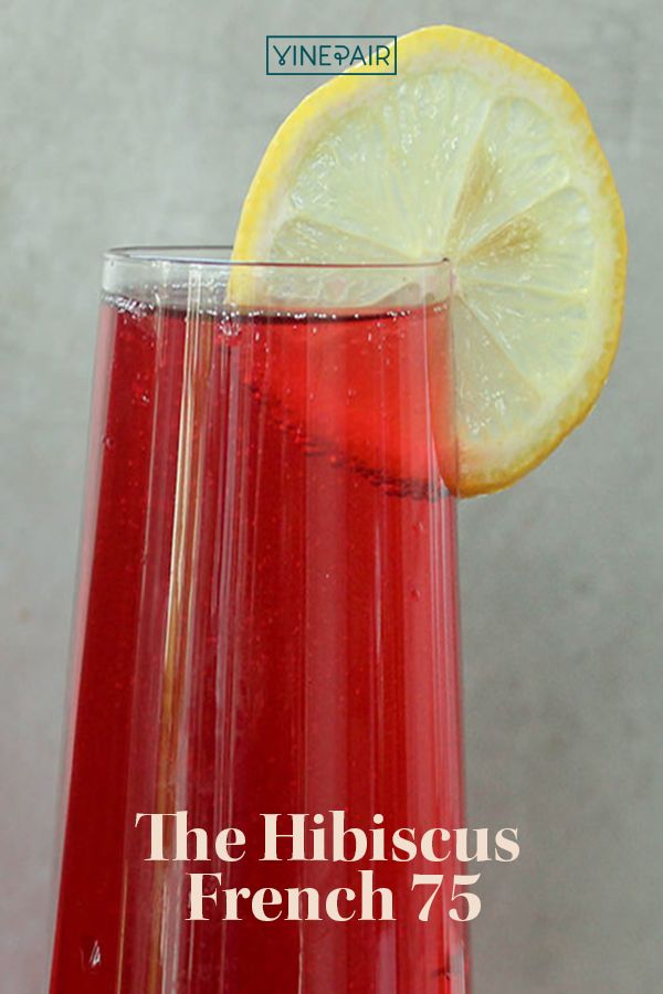 a tall glass filled with liquid next to a slice of lemon