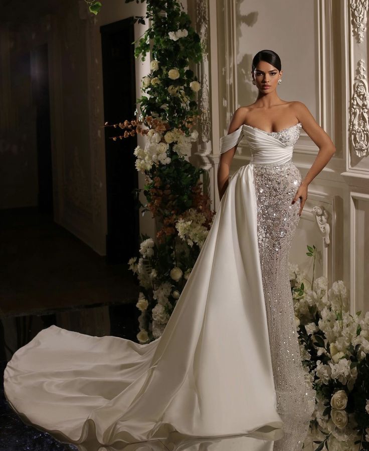 a woman in a wedding dress standing next to flowers