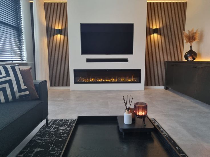 a living room with a fireplace, couch and coffee table in front of the tv