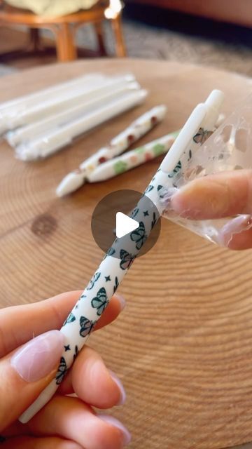 a person holding a toothbrush in their hand with other items on the table behind them