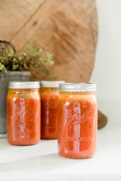 three jars of tomato sauce sit on a counter