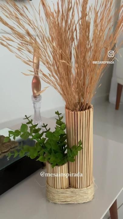 a vase with some plants in it on a table