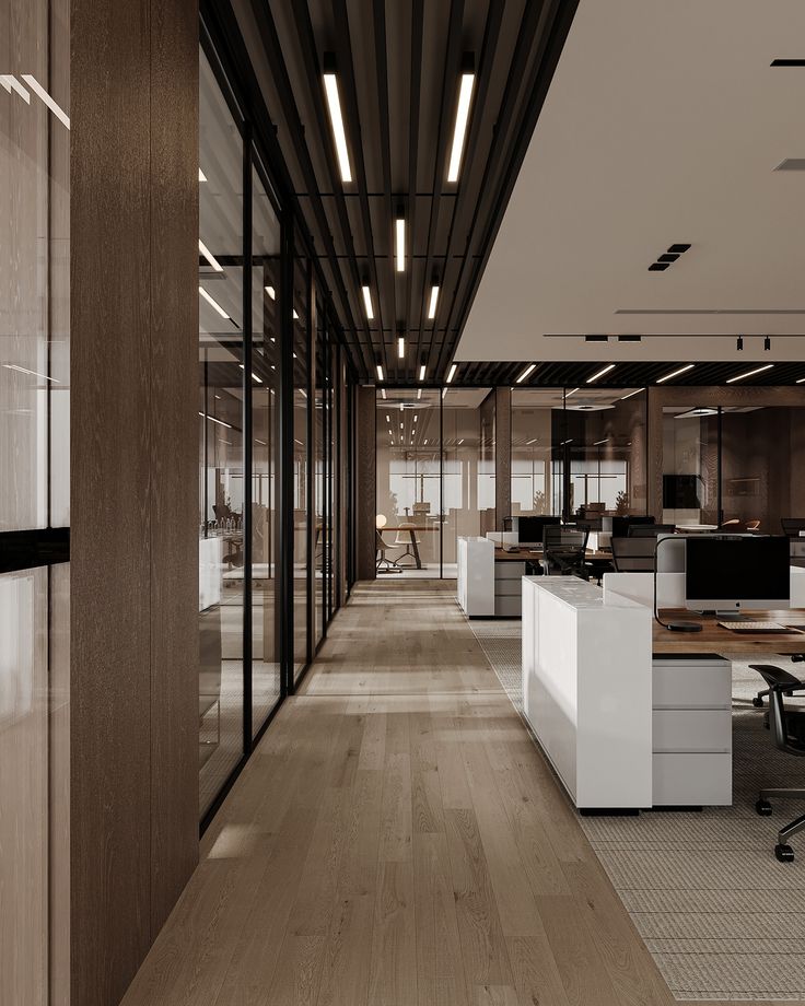 an empty office with wooden floors and glass walls, along with desks and chairs