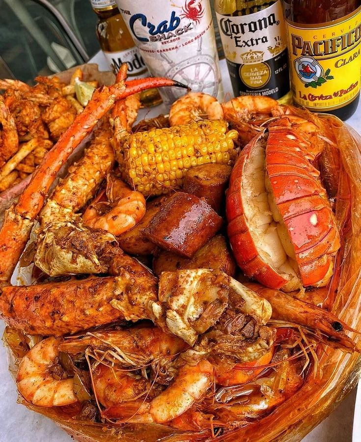 a basket filled with lots of different types of seafood and other foods on top of a table