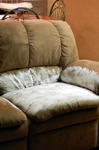 a brown couch sitting next to a wooden table