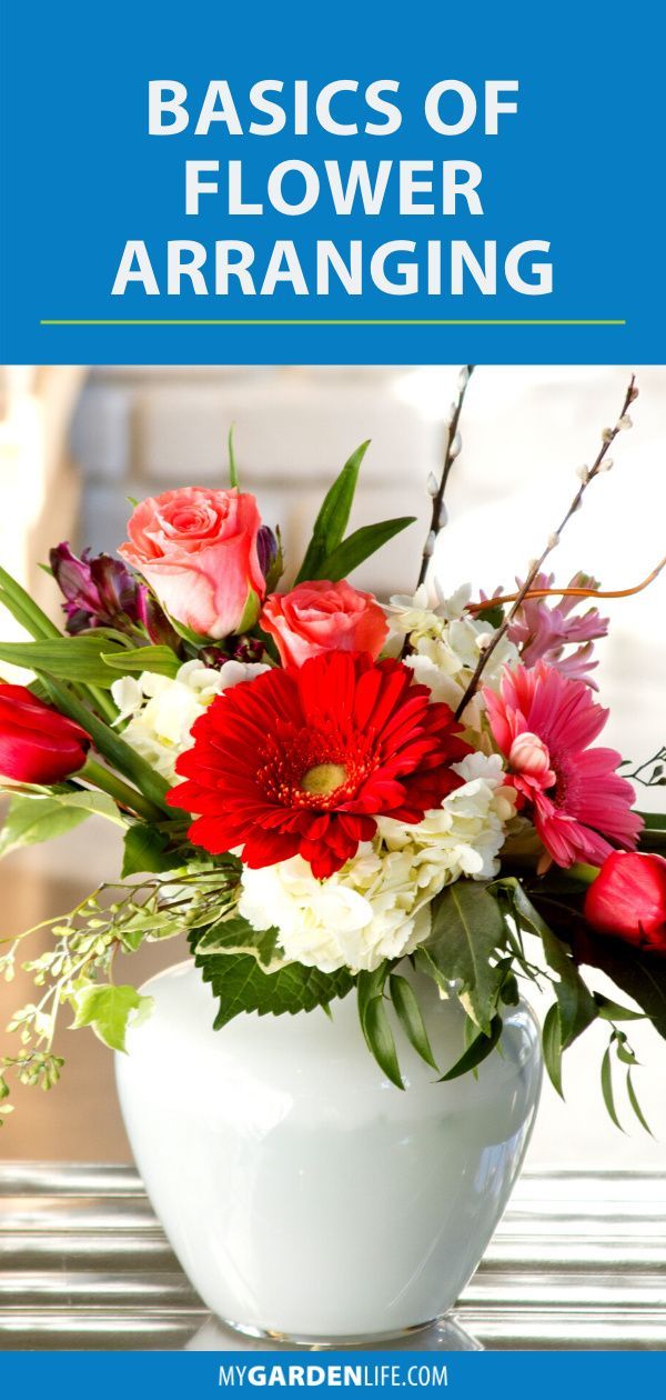 a white vase filled with red and white flowers