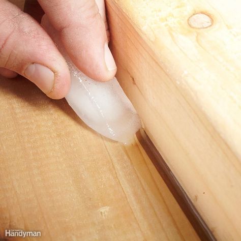 a person using a knife to cut something on a wooden surface with a piece of wood in the foreground