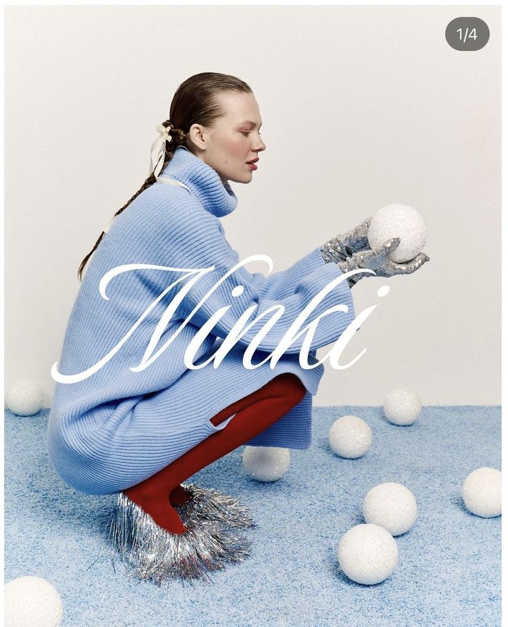 a woman sitting on top of a blue carpet next to white balls in the air