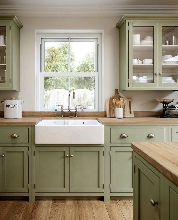 a kitchen with green cabinets and wooden floors