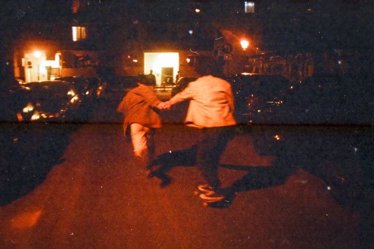 two people are skateboarding in the dark at night