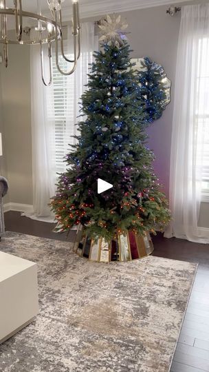 a living room with a christmas tree and chandelier