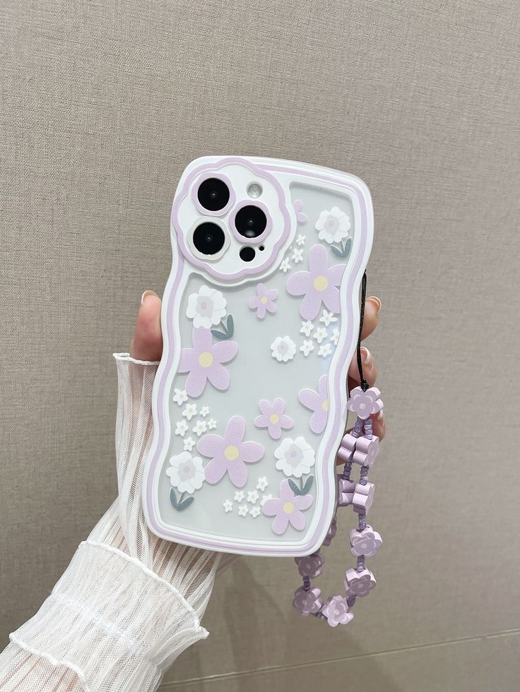 a person holding up a phone case with flowers on it