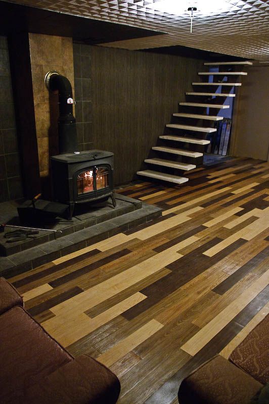 a living room with wood floors and a fire place in the corner next to stairs