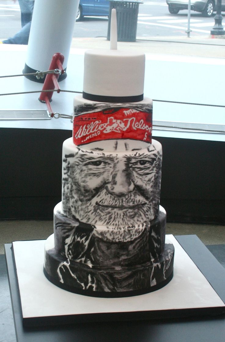 a three tiered cake with an old man's face on it