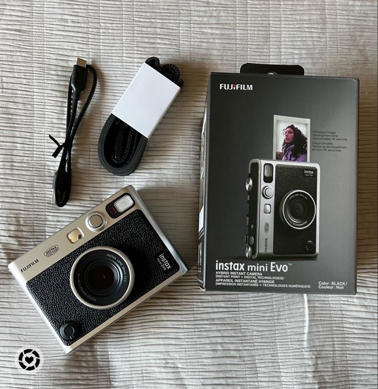 an instax mini - ev camera with its box and charger