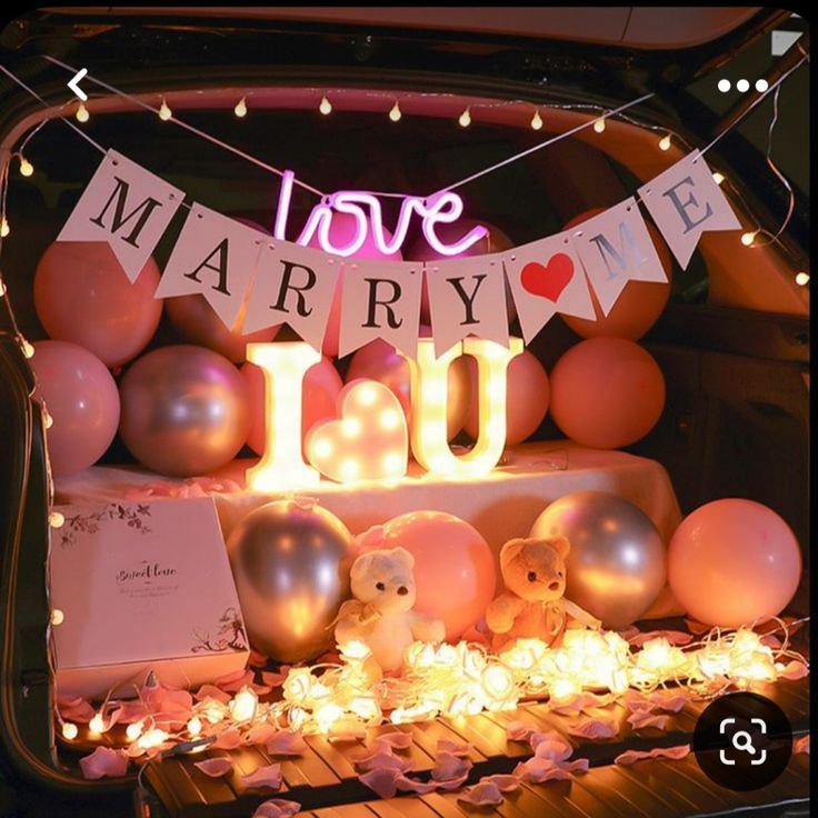 the trunk of a car with balloons and lights on it, including an i love married sign