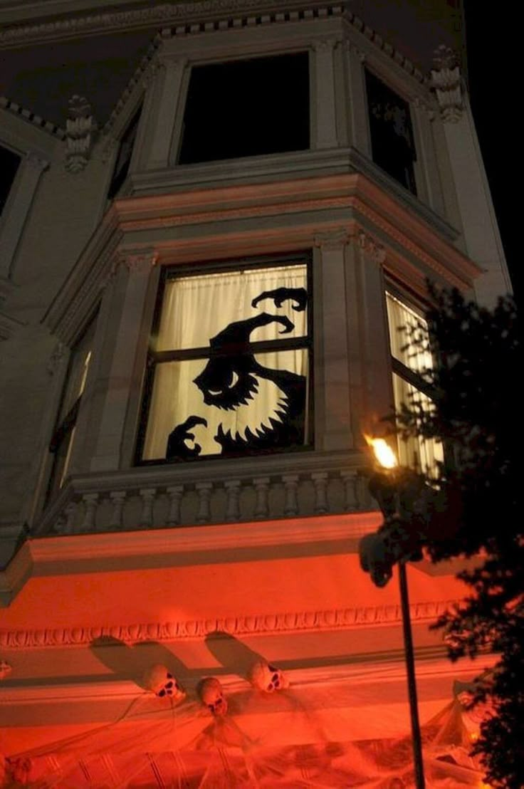 a clock tower with an eagle on it's face and windows lit up at night