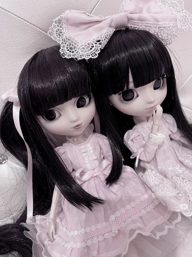 two dolls are sitting next to each other