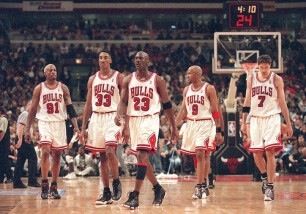 the chicago bulls are walking on the court in front of an arena full of fans