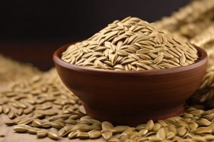 a brown bowl filled with sunflower seeds on top of a table