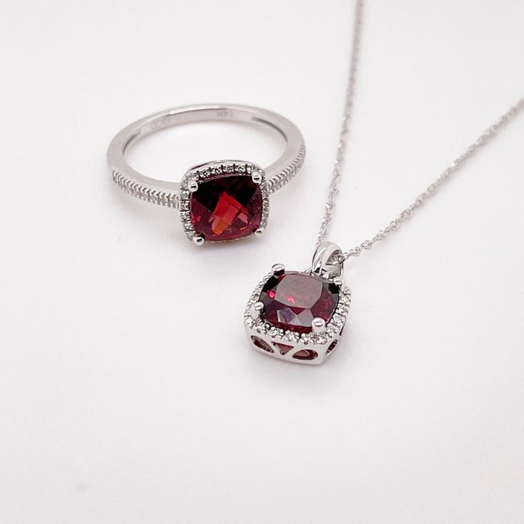 This deep red cushion-cut garnet is breathtaking and set beautifully within a diamond halo. This necklace was designed with a matching ring as shown in the pictures. These two make a stunning set that is the perfect addition to any jewelry collection. The necklace looks great on any woman as it will match their lipstick and lips! The details for this beautiful necklace are listed below:Metal Quality: 14K White GoldPendant Style: Garnet Diamond HaloDiamond Number: 20Diamond Shape: Round Brilliant Elegant Jewelry With Gemstone Accents And Round Cut, Formal Jewelry With Halo Design, Red Fine Jewelry As A Gift For Her, Elegant Cushion Cut Lab-created Ruby Jewelry, Formal Ruby Necklace With Halo Setting, Classic Cushion Cut Ruby Jewelry, Formal Halo Jewelry With Lab-created Ruby, Diamond Cut Ruby Jewelry As Gift, Classic Jewelry With Diamond Accents And Lab-created Ruby